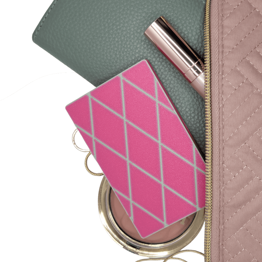 roxy pepperton birth control travel pilll case spilling out of a makeup bag with other makeup and travel accessories to get ready for vacation